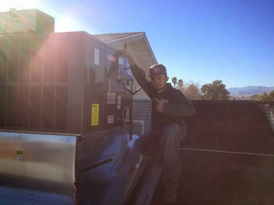 HVAC technician performing AC Tune-Up on a rooftop unit in Farmington